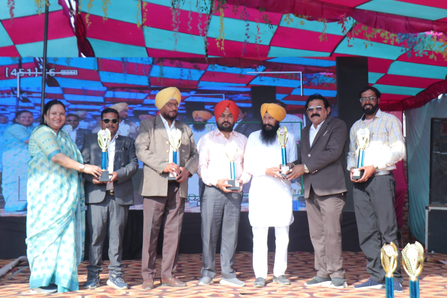 Students and staff receiving trophies at a recognition ceremony